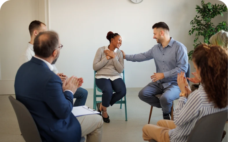 People clapping in a circle meeting