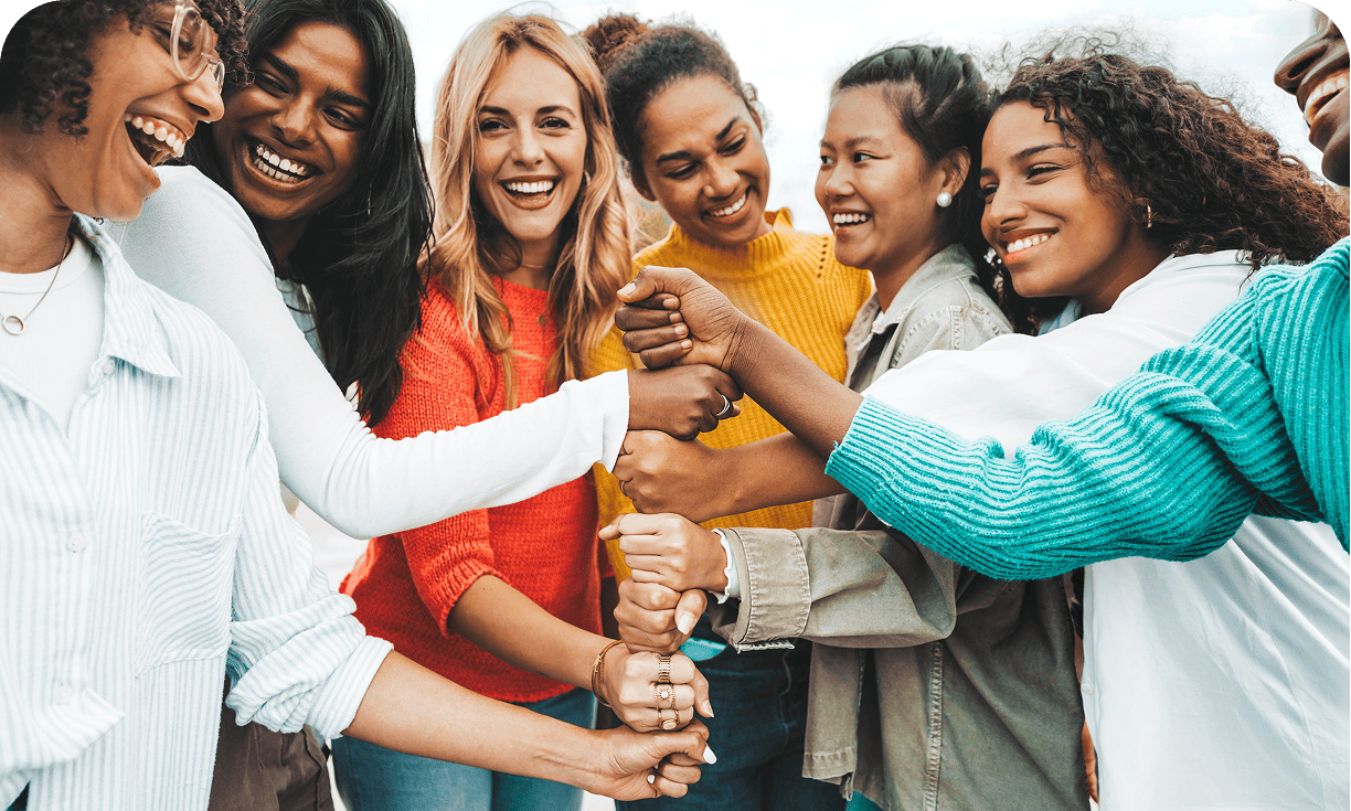 Diverse women smiling and holding hands