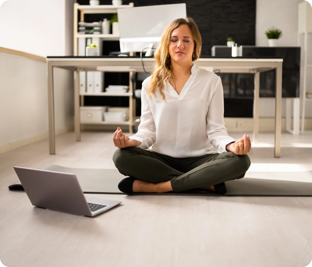 Woman meditating on yoga mat at home